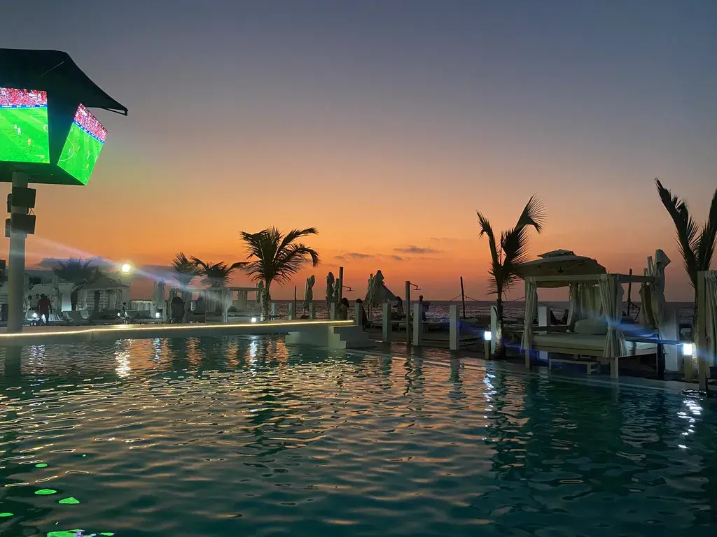 Lookal pool at sunset with the sea in the background